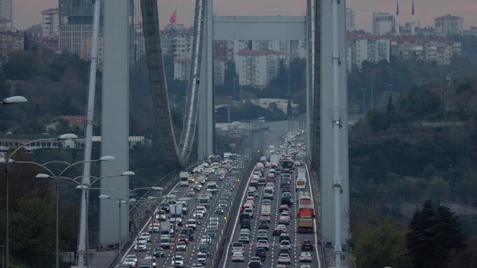 高角度手持拍摄的交通移动在高高的博斯普鲁斯桥对天空在日落期间在伊斯坦布尔，土耳其