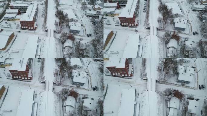 在结冰的道路上，汽车行驶在积雪覆盖的铁轨下，鸟瞰向下倾斜