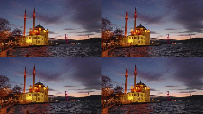 手持拍摄的灯光Ortakoy清真寺和博斯普鲁斯大桥在黄昏多云的天空