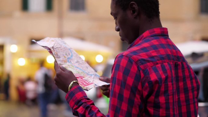 年轻的美国非洲游客在罗马地图上寻找正确的方向
