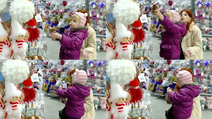 一个年轻的女人和一个小女孩在圣诞玩具店