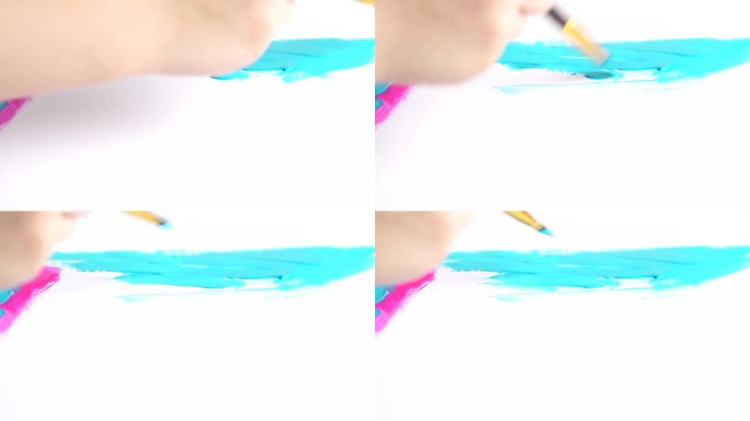 孩子手握画笔画油画的特写。在画布上画蓝色和粉红色的线条。