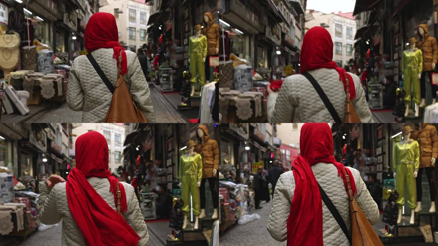 土耳其伊斯坦布尔，一名妇女带着钱包走在市场上的后视图