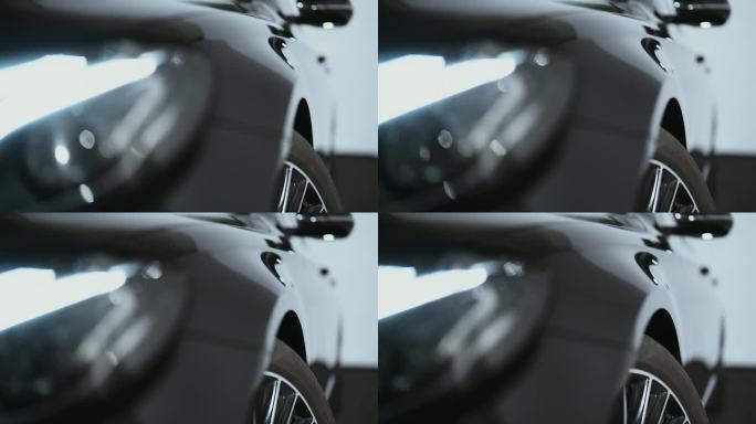 极近距离的相机pan闪亮的反光黑色金属表面的一个全新的蜡车侧面和车轮