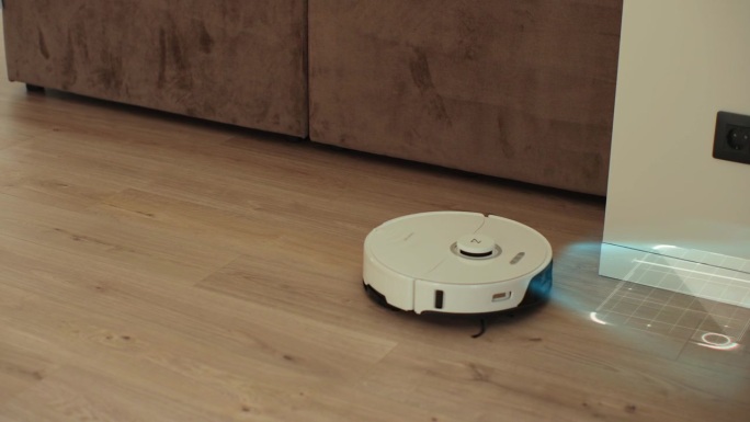 白色机器人真空吸尘器扫描强化木地板。探测器有助于识别墙壁和物体并优化清洁。智能未来清洁设备。创建清理