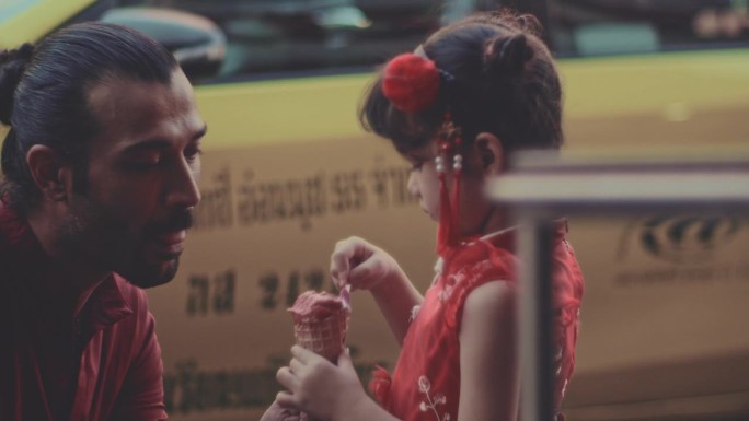 在唐人街吃冰淇淋红裙女孩夏日调皮甜美微笑