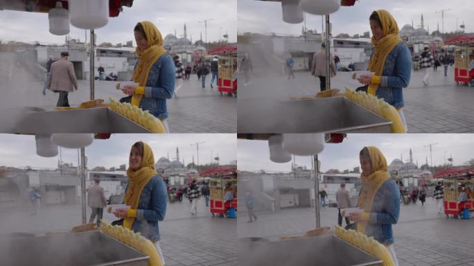 土耳其伊斯坦布尔，一名女游客手持相机在街头市场买烤玉米