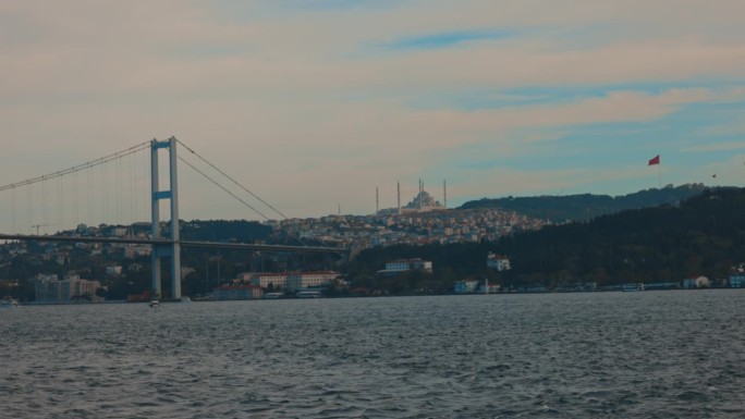 土耳其伊斯坦布尔多云的天空下，博斯普鲁斯大桥上的蓝色清真寺