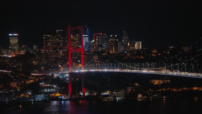 夜晚的伊斯坦布尔。平稳的交通行驶在法提赫苏丹穆罕默德桥与背景城市景观在晚上。