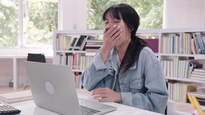 年轻的亚洲女大学生们在大学图书馆里温文尔雅地读书，昏昏欲睡，最后进入了梦乡。传达学习的宁静时刻和偶尔