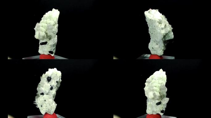 发现一颗未经切割的宝石。单个大晶莹剔透的宝石。粗糙的水晶在聚光灯下闪闪发光。黑色碧玺镶嵌在云母上，黑