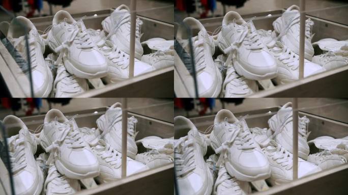 鞋出售。商店里有新的白色运动鞋。休闲平底鞋。特写镜头。白色运动鞋的盒子。在商场或超级市场的鞋店或鞋部