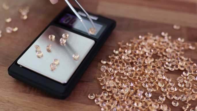 珠宝商在工厂用电子秤称宝石的重量