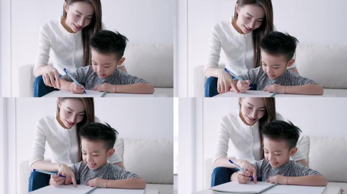 年轻的母亲检查家庭作业，帮助孩子在家学习