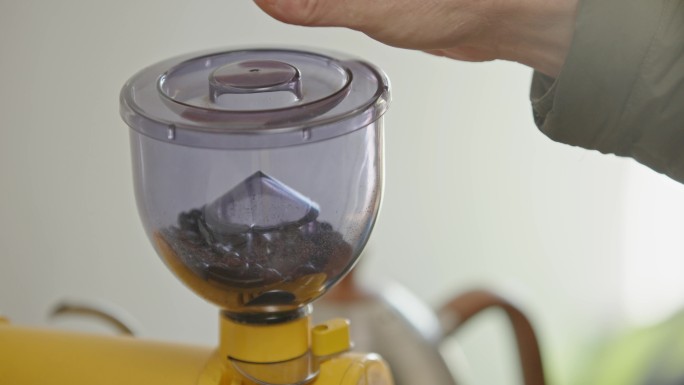 咖啡豆高处慢动作掉落在咖啡磨豆机上