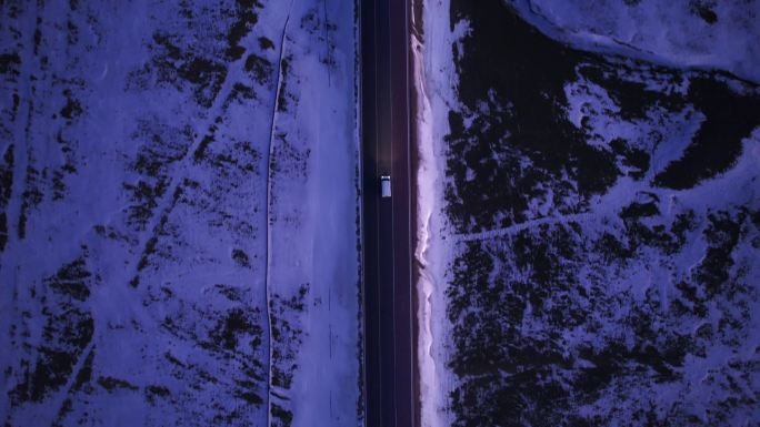 傍晚行驶在雪地公路的汽车