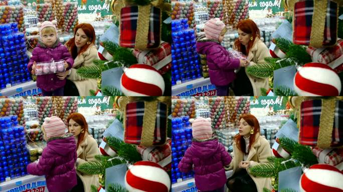 在一家商店里，一对母女正在挑选玩具来装饰圣诞树