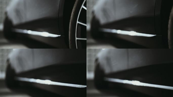 极近距离低角度相机盘闪亮的反光黑色金属表面的一个全新的蜡车侧面和车轮