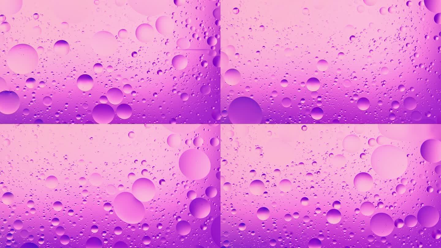 超慢动作流动的粉红色的油泡在水中。