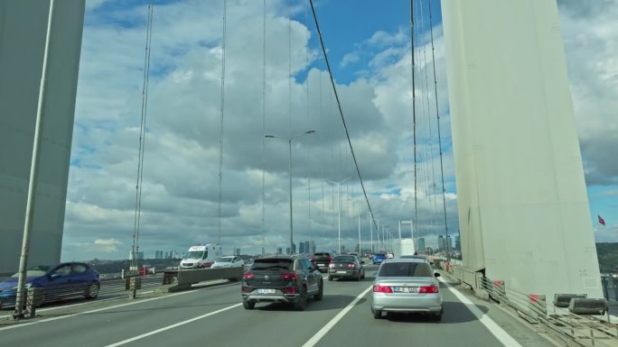 在晴朗的一天，土耳其伊斯坦布尔，汽车在高高的博斯普鲁斯大桥上移动的手持镜头