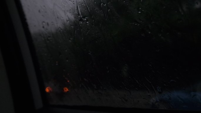 雨水滴落在车窗上缓缓落下