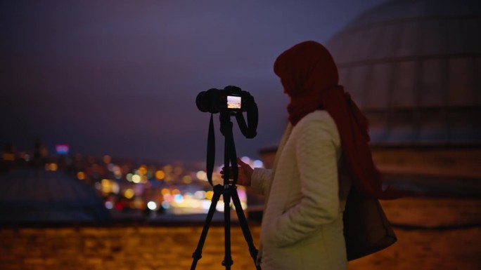 女子在苏莱曼清真寺用相机和三脚架捕捉令人惊叹的夜景