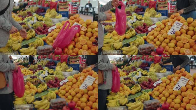 土耳其伊斯坦布尔，一名妇女手持相机从摊贩手中购买水果
