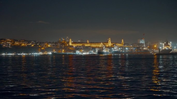 土耳其伊斯坦布尔，夜晚晴朗的天空下，马尔马拉海照亮的Kuleli军事高中的船视角