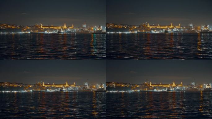 土耳其伊斯坦布尔，夜晚晴朗的天空下，马尔马拉海照亮的Kuleli军事高中的船视角
