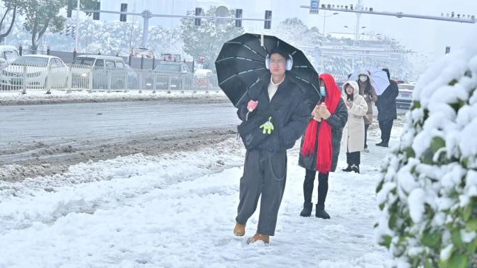 下雪天，公交车站台，冒雪等候公交车的人群