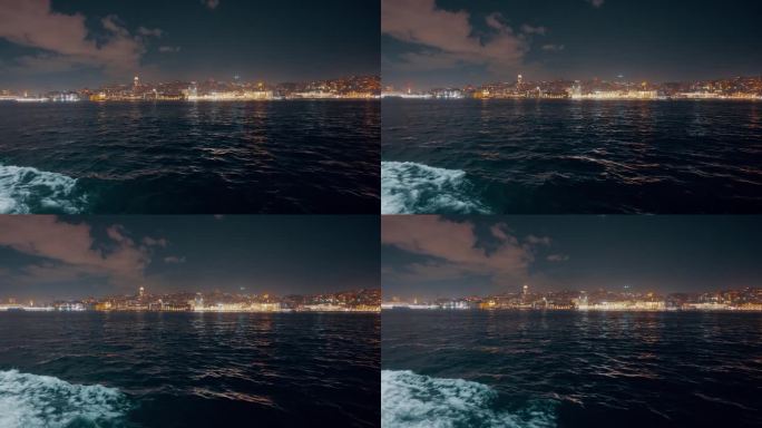 船的视角照亮城市景观的马尔马拉海对天空在夜间伊斯坦布尔，土耳其
