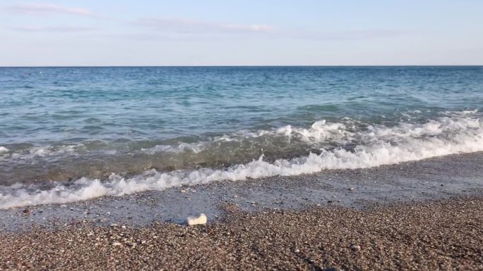 在阳光明媚的日子里，海浪和石头海岸的海滩风景秀丽