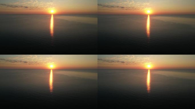 4K无人机视频。海在日落时分，倒影在水中
