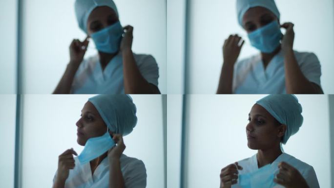 疲惫不堪的年轻非洲女医生或护士的特写肖像，戴着统一的医疗帽，在做完手术后摘下口罩