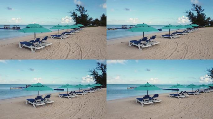 阳光明媚的早晨，沙滩椅和遮阳伞的轨道照片