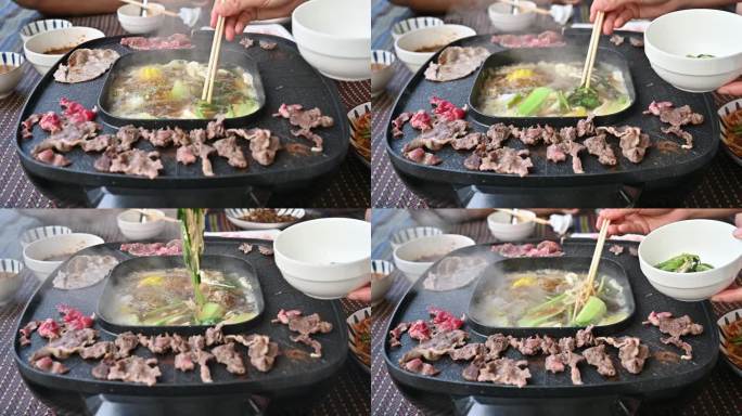 人们享受韩国烧烤和涮锅涮锅晚餐的派对画面。