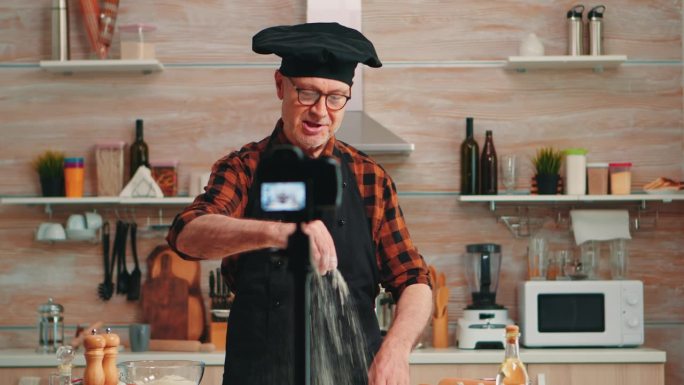 积极的厨师在厨房录制视频的肖像
