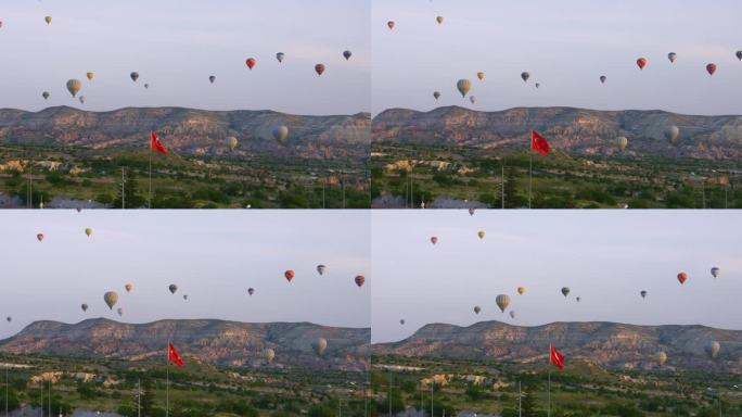 无人机-热气球，卡帕多西亚，土耳其2023 -飞向红色和白色的热气球与其他在城市上空