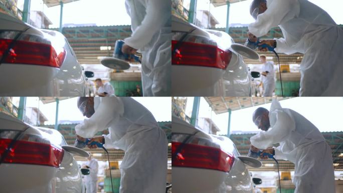 修理工在修理厂用机械抛光机抛光汽车表面。