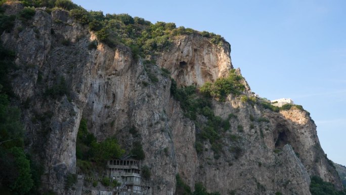 在晴朗的蓝天下，阿马尔菲海岸岩石上孤独的房子的特写。坎帕尼亚阿马尔菲海岸的波西塔诺村。悬崖上的意大利