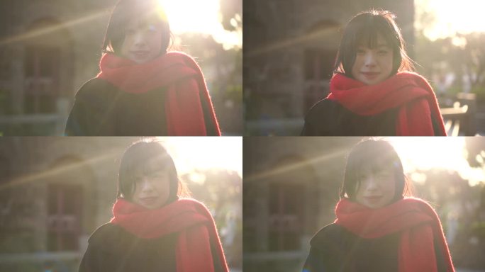 冬天阳光下带红色围巾的美女看着镜头微笑
