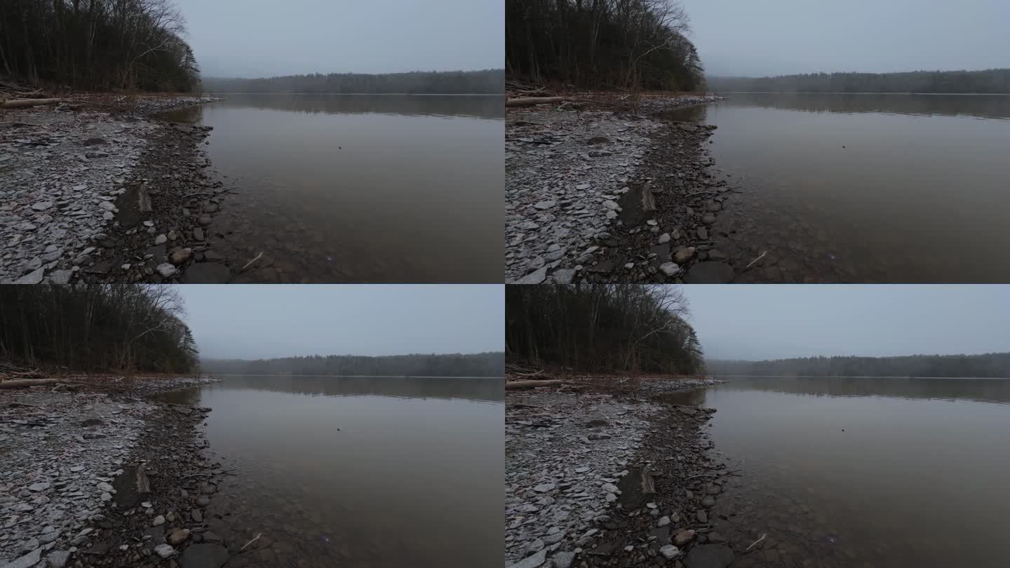 在一个原始而美丽的山间湖泊的岩石岸边，一场巨大的暴风雪开始了