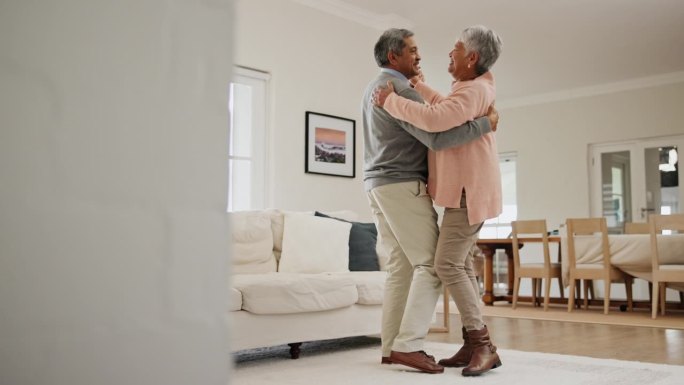老年人，夫妇和拥抱跳舞在家里的客厅为纽带，浪漫和幸福或爱。老人，男人和女人手牵着手或在客厅跳舞庆祝或