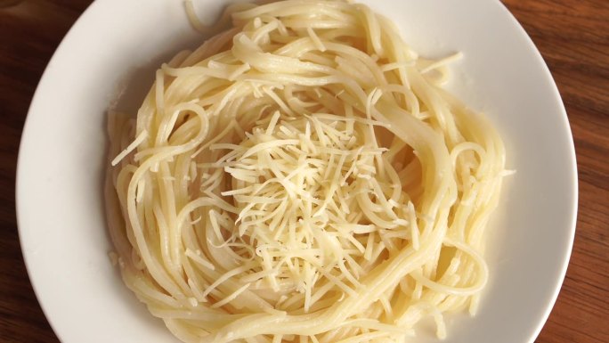 热的意大利面撒上磨碎的奶酪