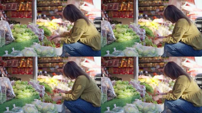 年轻的亚洲女游客在当地市场挑选小胡萝卜。健康妇女在市场上挑选新鲜蔬菜。蔬菜水果概念