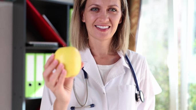 医生手捧黄苹果，提倡健康生活方式