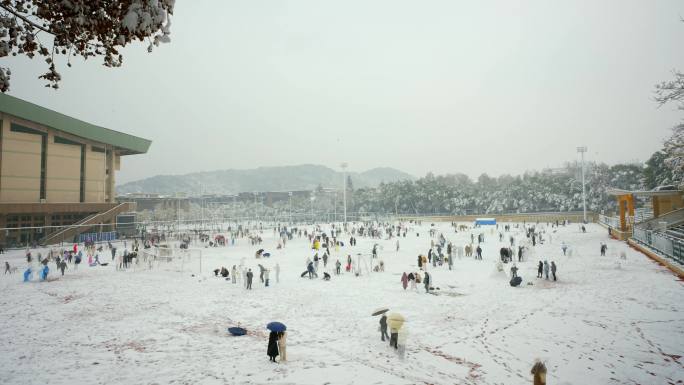 下雪天操场上开心玩耍的人群延时