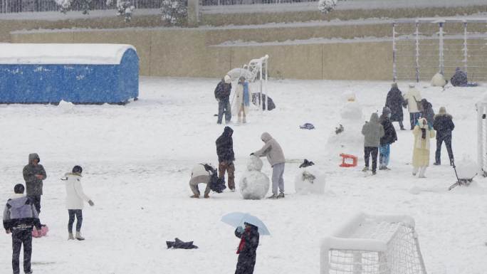 下雪天操场上欢乐玩耍的人群