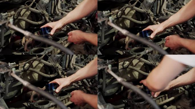 汽车修理工使用环形压缩工具在发动机机体内安装活塞进行大修。手工工作一丝不苟地对准组件组装，展示了详细