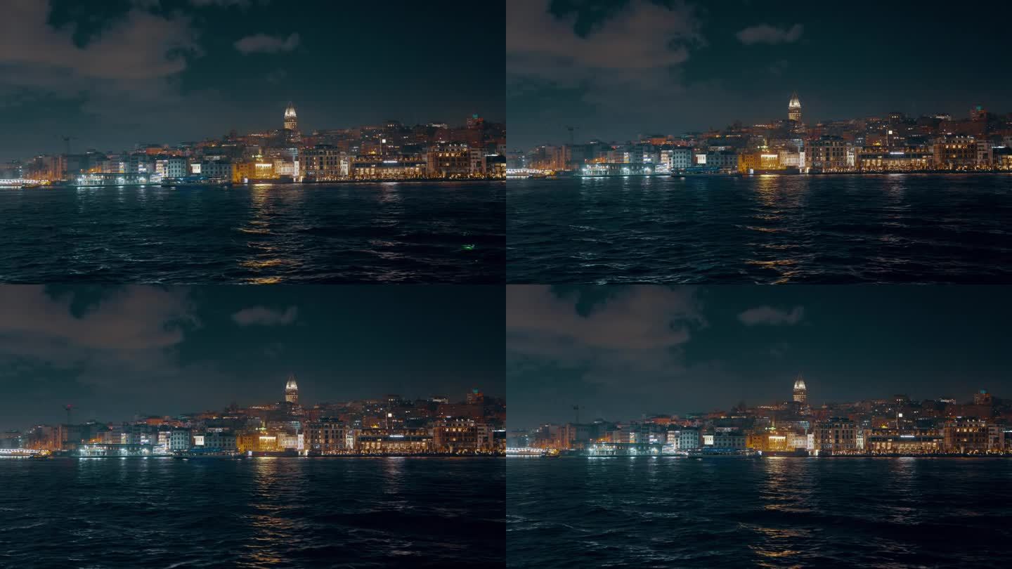 船的视角照亮塔和城市景观的马尔马拉海对天空在伊斯坦布尔，土耳其